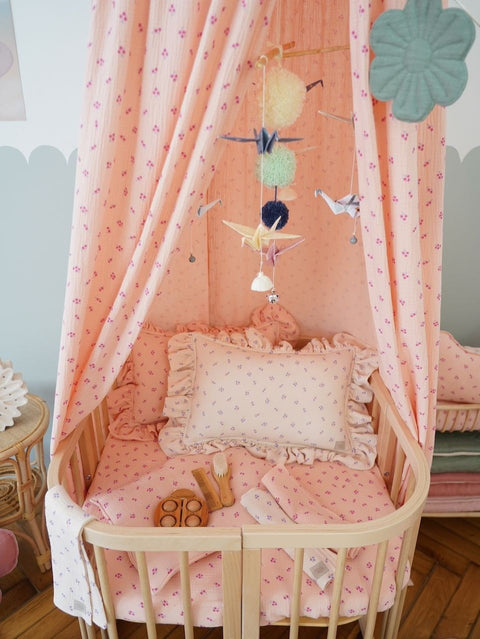 1. Nursery with pink canopy and wooden crib featuring Moi Mili pastel origami mobile with paper cranes and pompoms