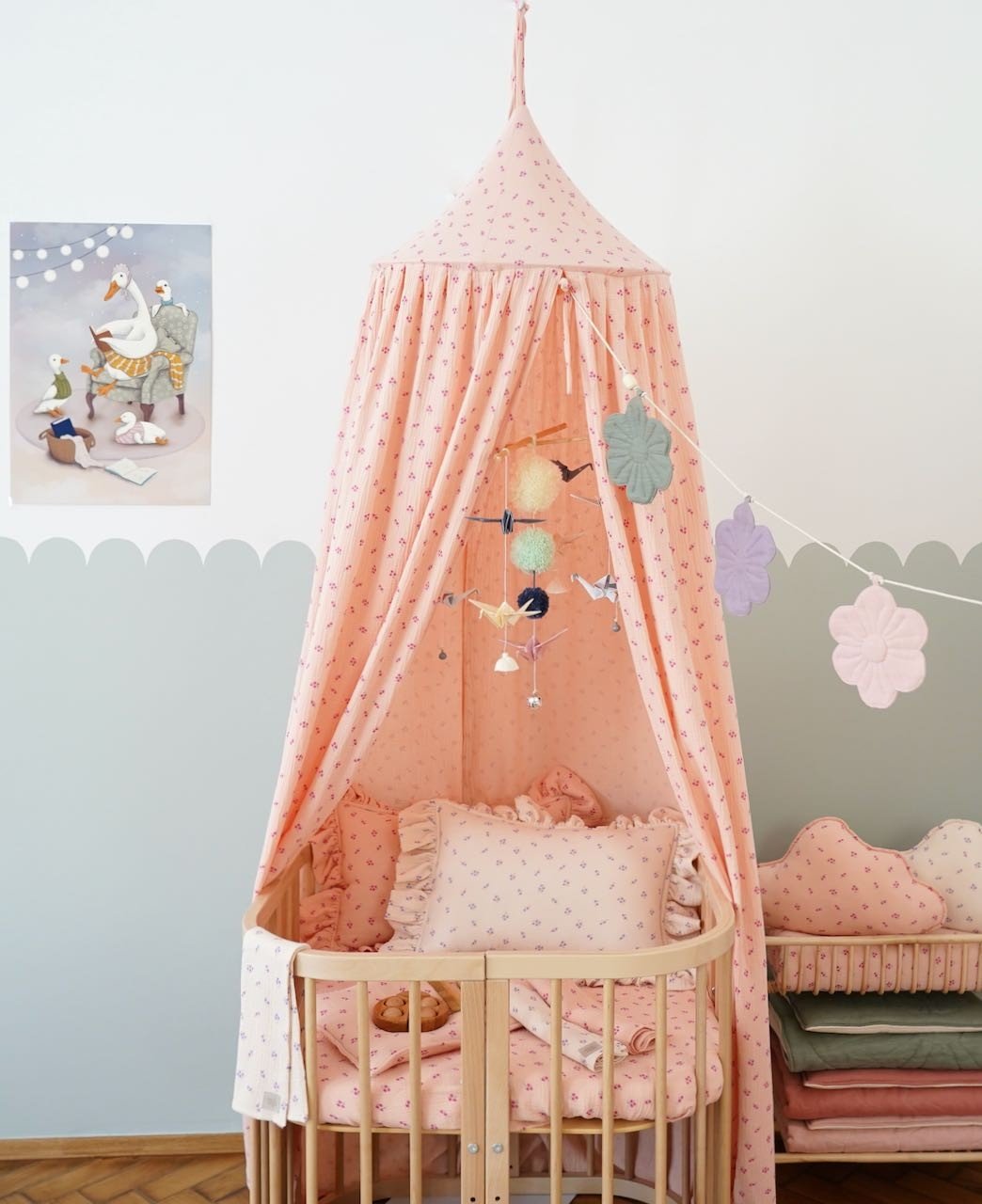 5. Nursery with pink canopy and crib featuring Moi Mili pastel origami mobile and decorative pillows