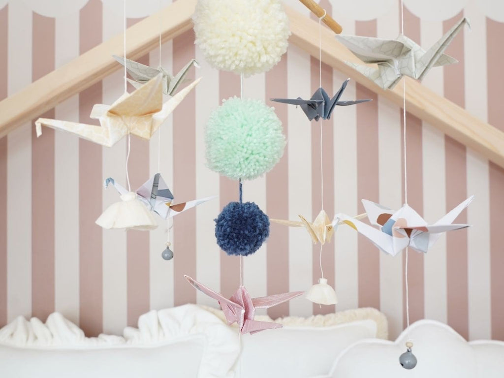 3. Close-up of Moi Mili pastel origami mobile with paper cranes and yarn pompoms