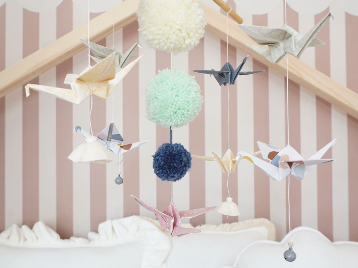3. Close-up of Moi Mili pastel origami mobile with paper cranes and yarn pompoms