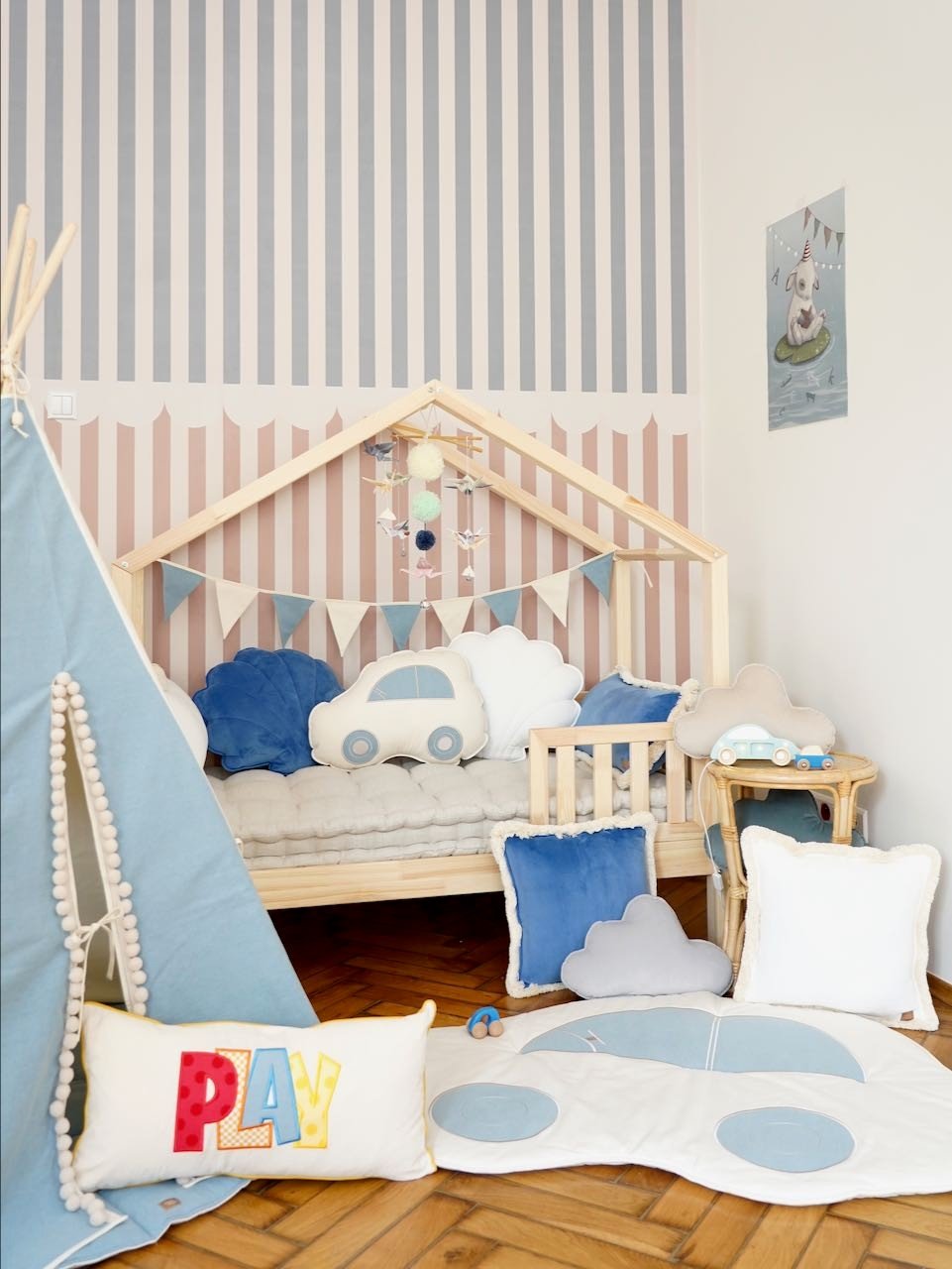 6. Children's room with striped wall and Moi Mili pastel origami mobile above bed with cloud pillows