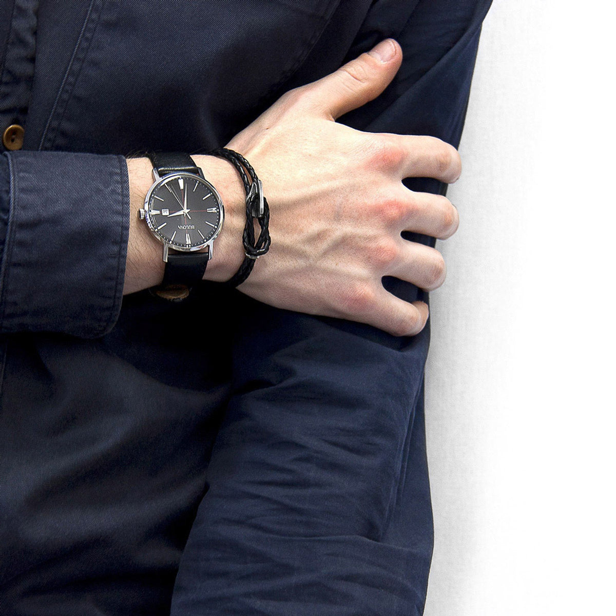1. Men's Padstow Silver and Braided Leather Bracelet in coal black worn with a watch, styled with a navy shirt