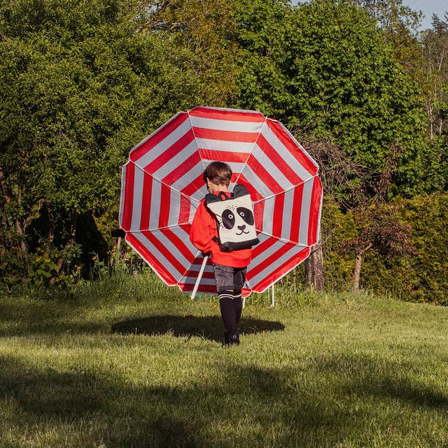 8. Child carrying Muni Panda backpack in a park, emphasizing outdoor use