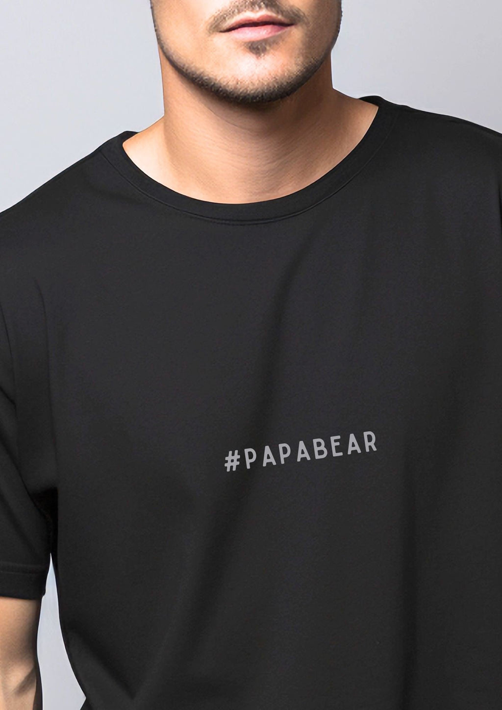2. Man wearing black #PAPABEAR T-shirt by Black Giraffe Brand, crafted from 100% organic cotton, shown in a studio setting with a neutral background