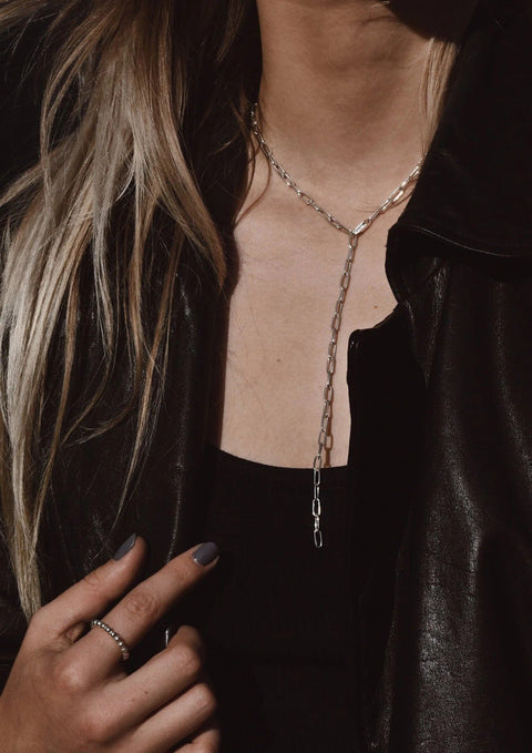 5. Woman wearing silver Y-shaped necklace with black top and leather jacket