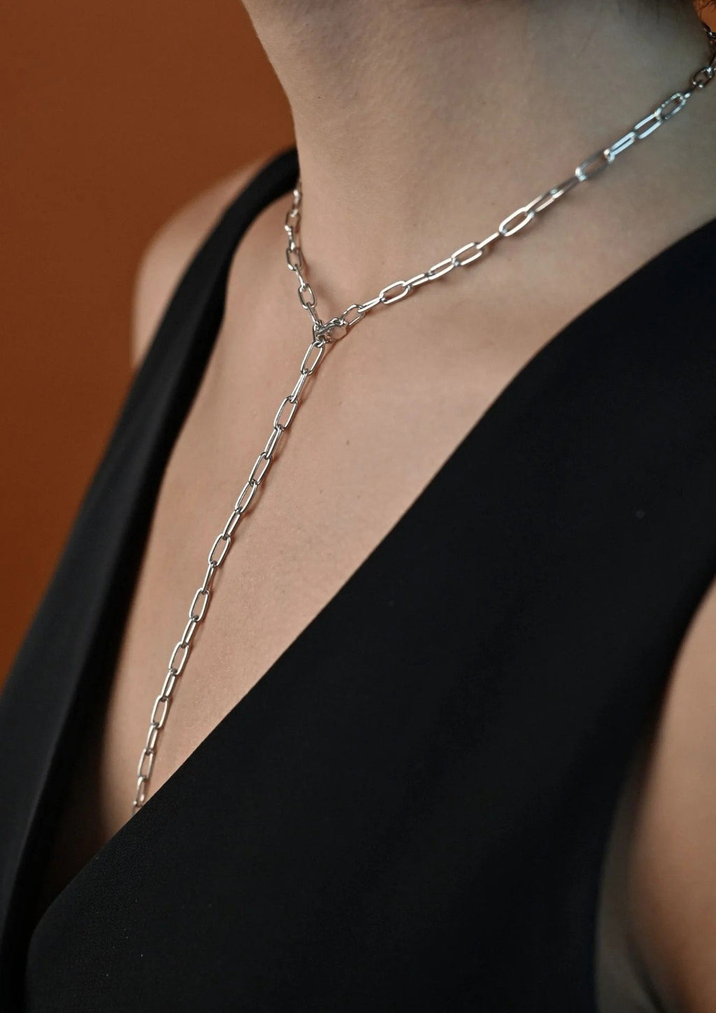 11. Woman wearing silver Y-shaped necklace with black V-neck top