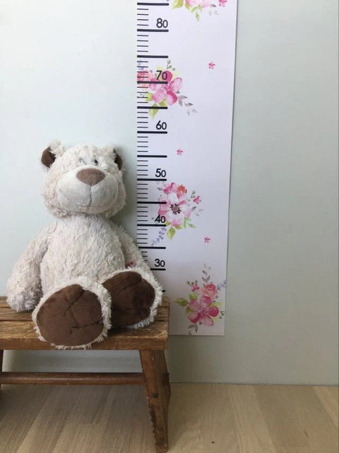 1. Children's growth chart with floral design next to plush bear on wooden stool against light wall