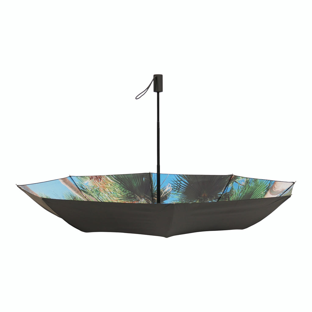 2. Studio shot of open Paradise Umbrella with tropical print and black exterior, highlighting windproof structure
