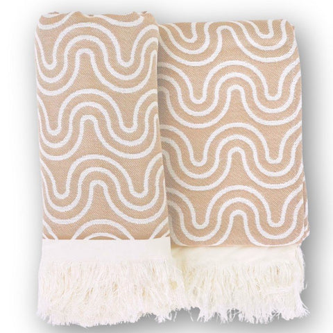 1. Beige bamboo towel with white wave pattern and fringed edges, folded on a white background