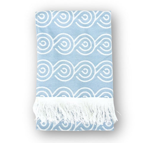 1. Blue bamboo towel with white swirl pattern and fringed edges, folded on a white background