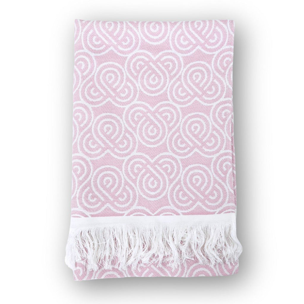 3. Pink bamboo towel with white loop pattern and fringed edges, folded on a white background