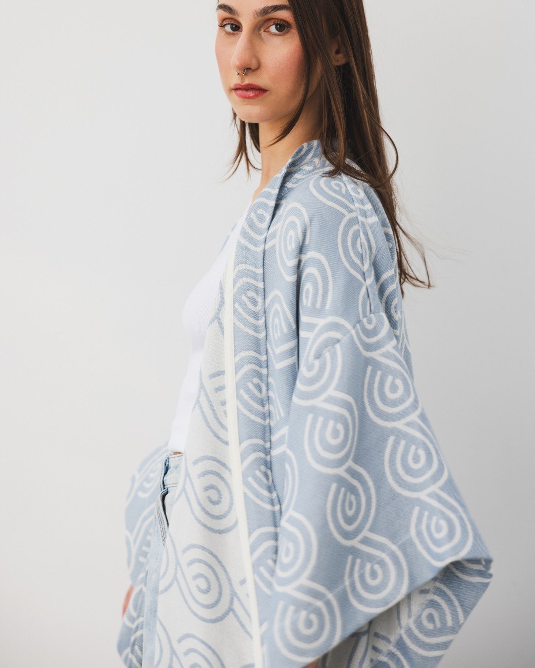 8. Side view of woman in Patulove blue bamboo kimono with swirl pattern, looking at camera