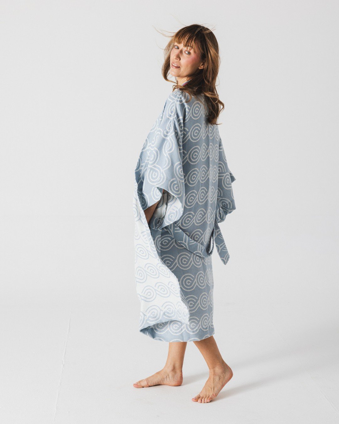 4. Woman in Patulove blue bamboo kimono with swirl pattern, shown from side in studio