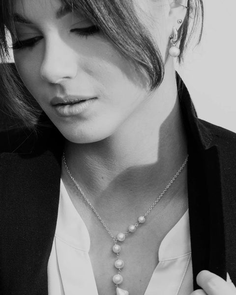 1. Woman wearing MyaMoon Pearl Dreamer Necklace in silver rhodium, styled with a blazer and blouse