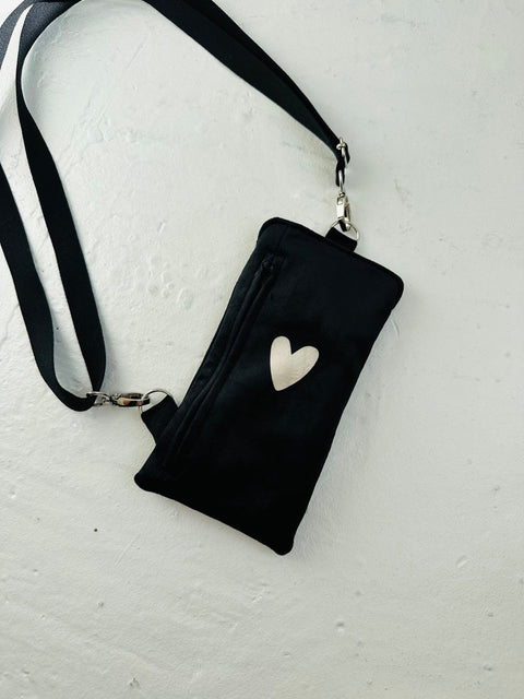 4. Flat lay of black velour phone bag with heart design by Garbanota, featuring front zippered pocket and adjustable strap