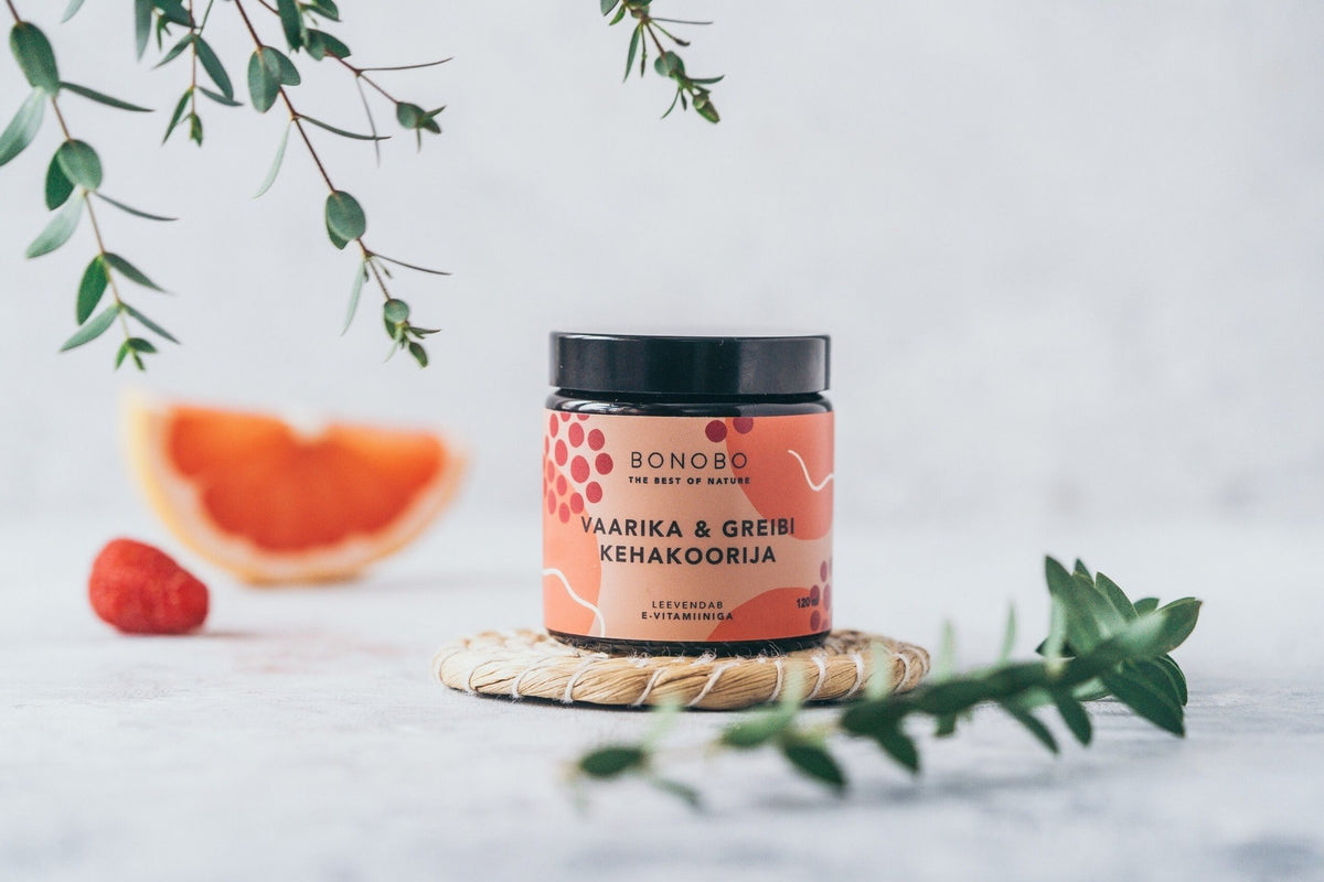 2. BONOBO Raspberry & Grapefruit body scrub jar on a woven mat with raspberry and grapefruit slice