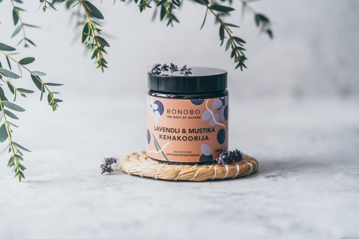 2. BONOBO Blueberry & Lavender body scrub jar on a woven mat with lavender sprigs