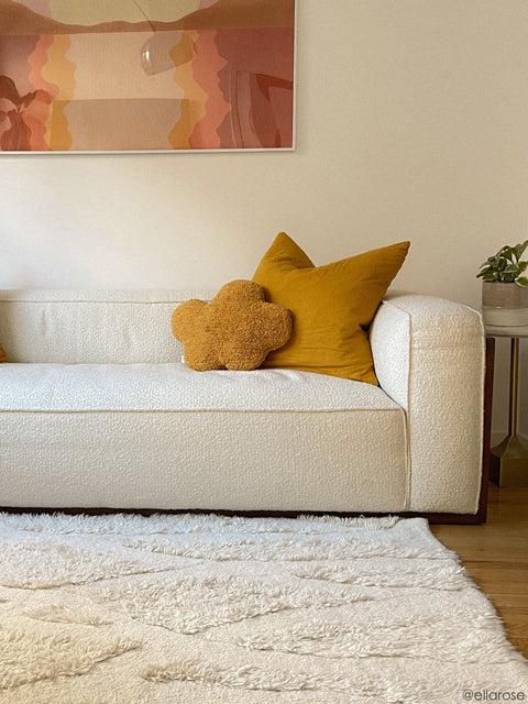 3. Mustard cloud pillow on white sofa with matching mustard cushion in a modern living room