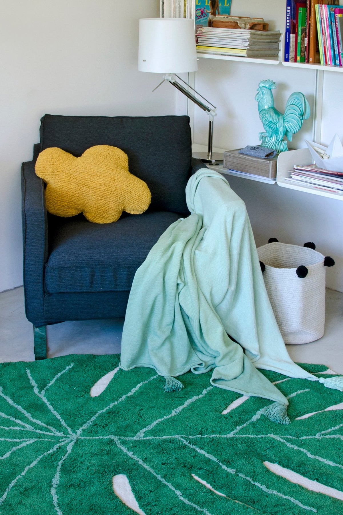 5. Mustard cloud pillow on dark armchair with mint green throw in a stylish room with green rug