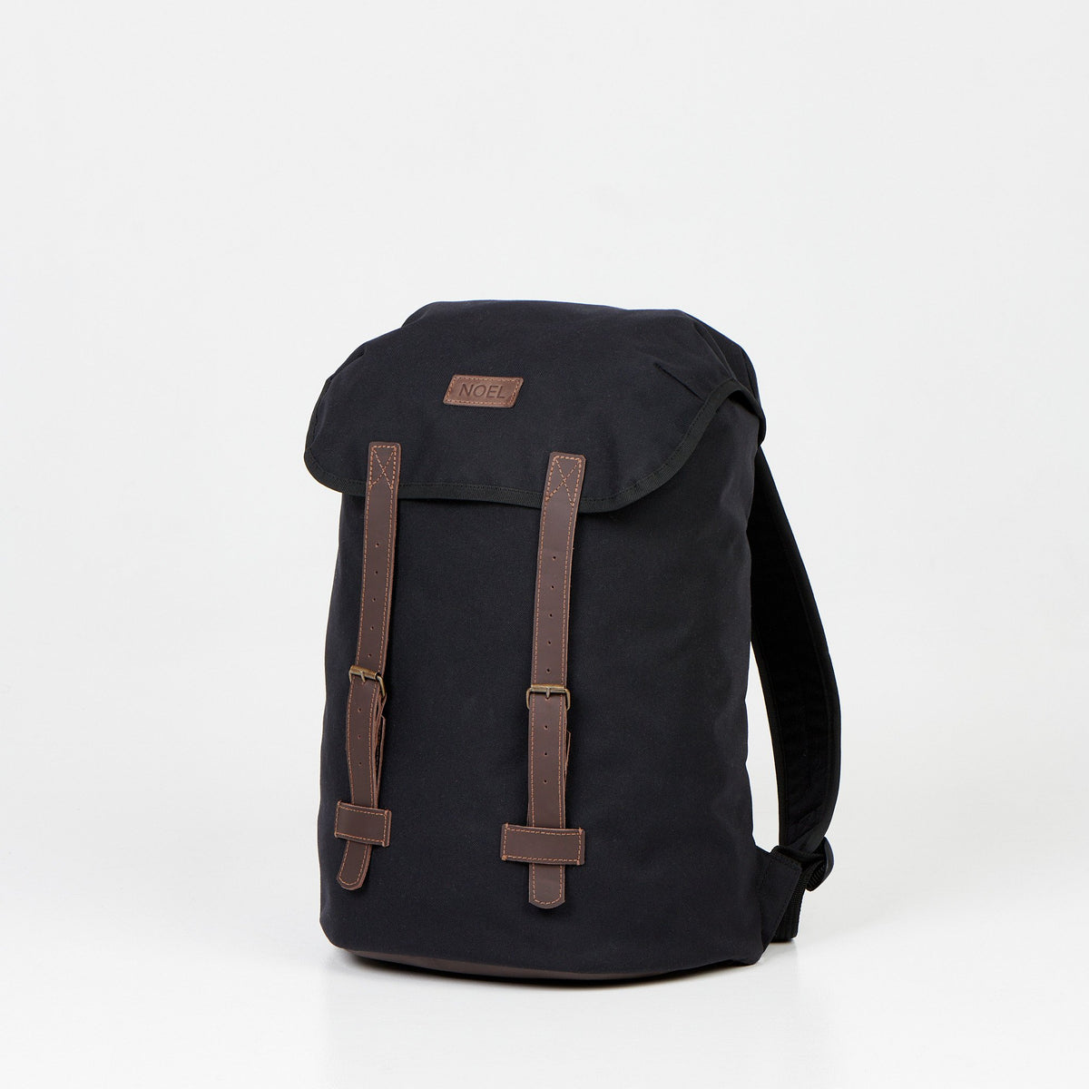 3. Angled view of Noel Cafe Handmade Backpack in black with brown detailing, studio setting