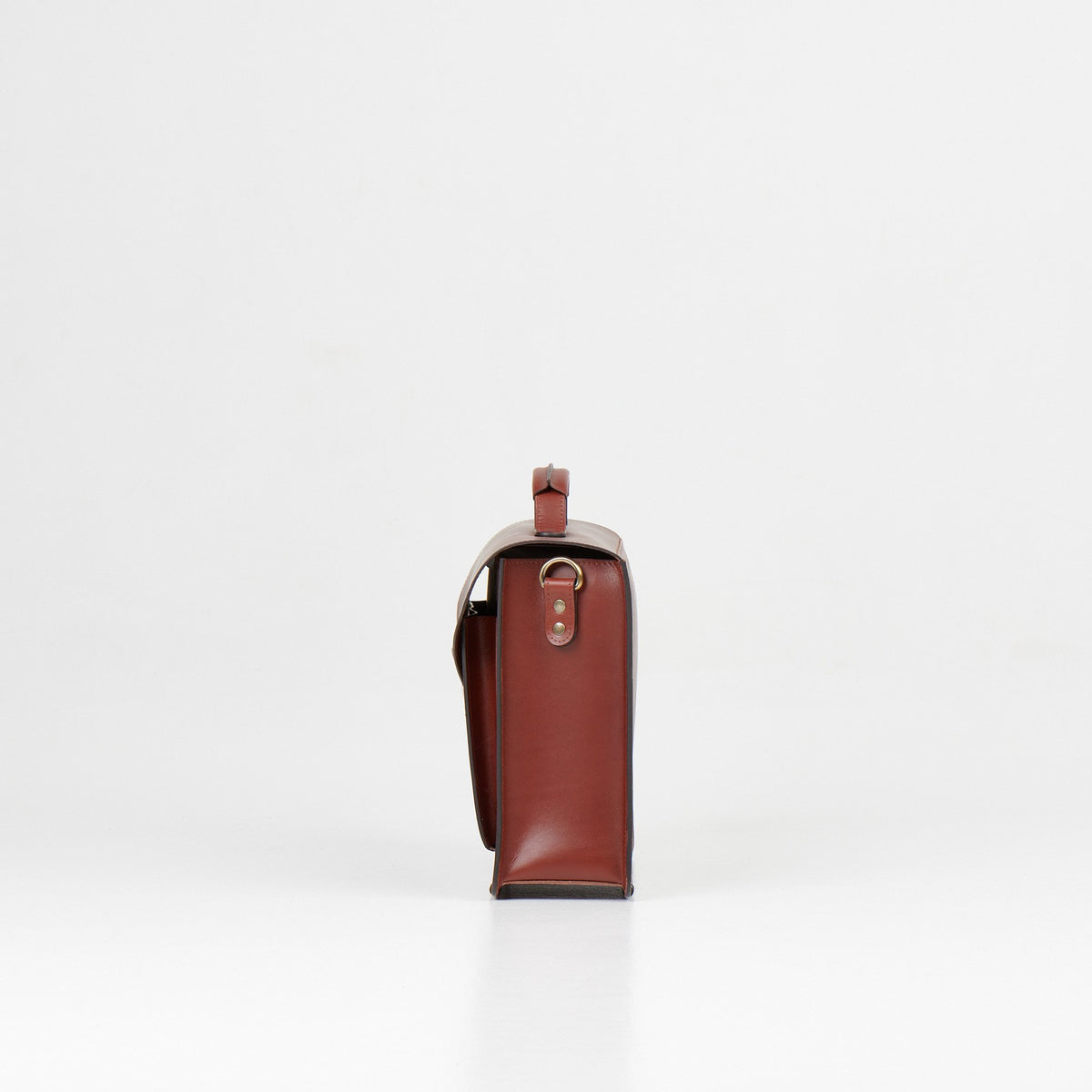 4. Side view of Papillon Briefcase No. 36 in cognac leather, highlighting thickness, studio setting