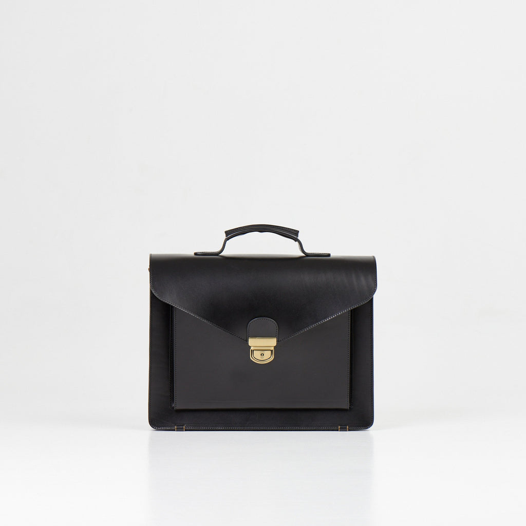 1. Papillon Briefcase No. 36 in black full-grain leather, front view with handle, studio setting