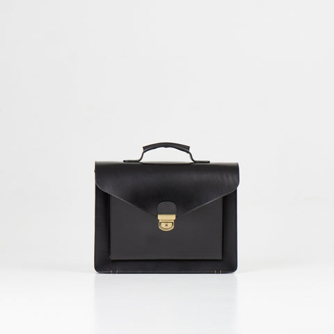 1. Papillon Briefcase No. 36 in black full-grain leather, front view with handle, studio setting