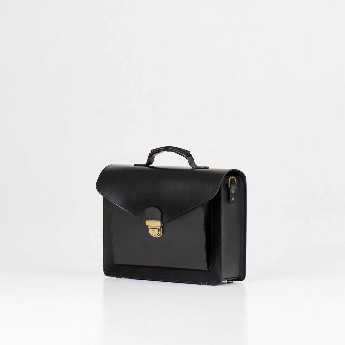 2. Papillon Briefcase No. 36 in black leather, angled side view showing clasp and handle, studio setting