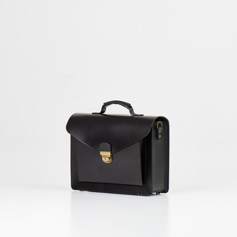 2. Papillon Briefcase No. 36 in black leather, angled side view showing clasp and handle, studio setting