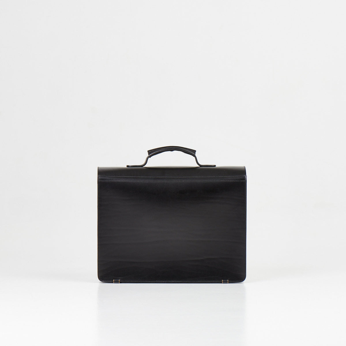 4. Back view of Papillon Briefcase No. 36 in black leather, showing smooth finish, studio setting
