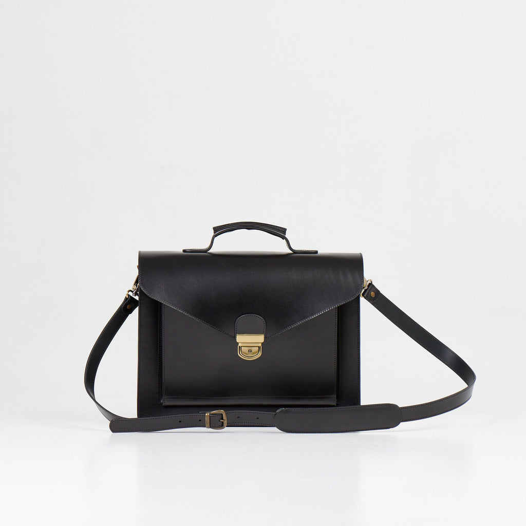 5. Papillon Briefcase No. 36 in black leather with adjustable shoulder strap, front view, studio setting