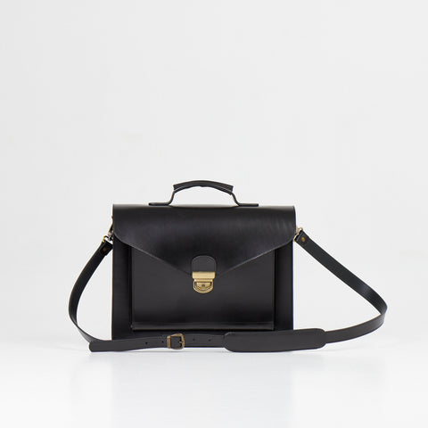 5. Papillon Briefcase No. 36 in black leather with adjustable shoulder strap, front view, studio setting
