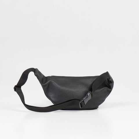 4. Flat lay of black leather waist bag showing back view with adjustable strap and buckle