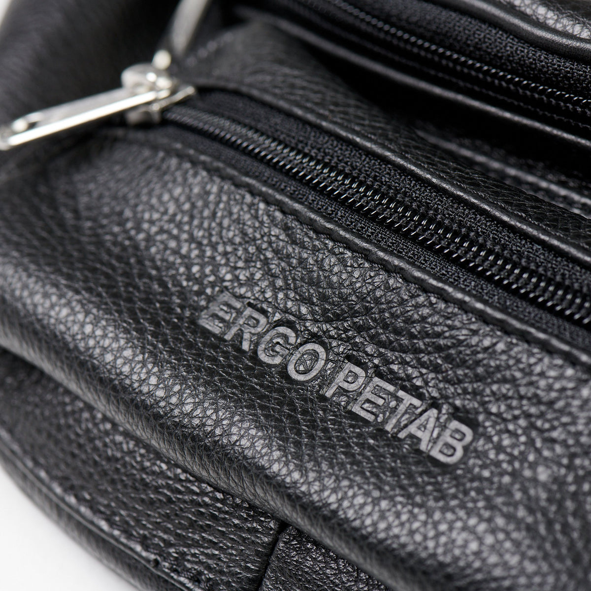 3. Close-up of ERGO PETAB logo embossed on black leather waist bag with visible zippers