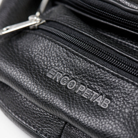3. Close-up of ERGO PETAB logo embossed on black leather waist bag with visible zippers