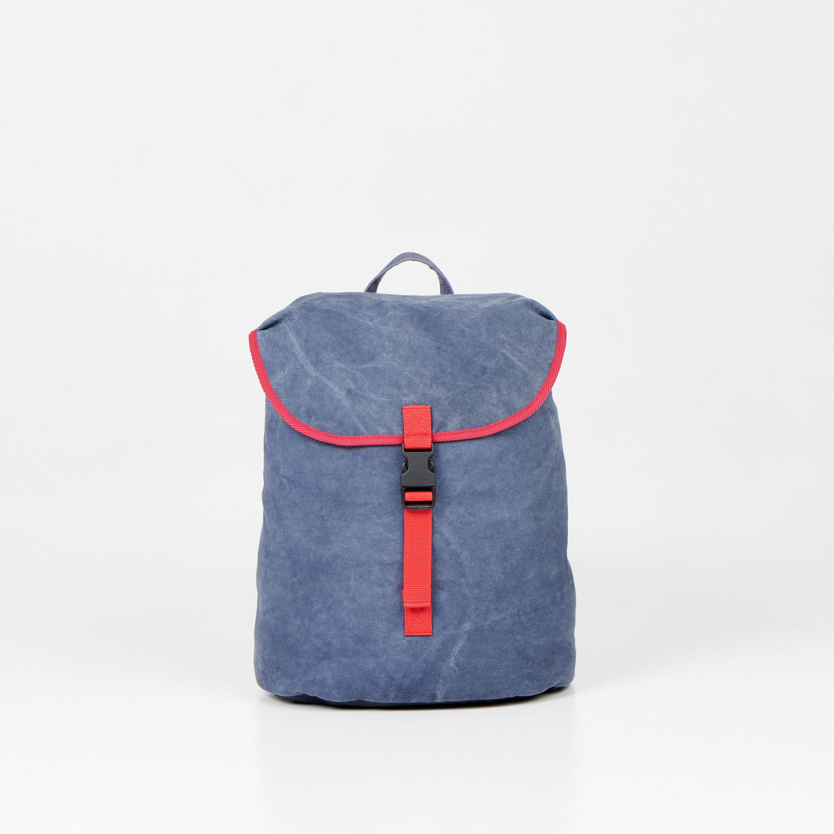 1. Noel Walker 12L backpack in blue canvas with red accents, front view in studio setting