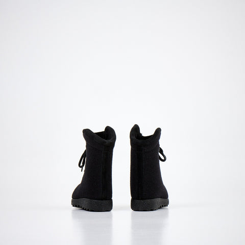 3. Pair of black kids' felt boots shown from back, highlighting heel and sole design on white background