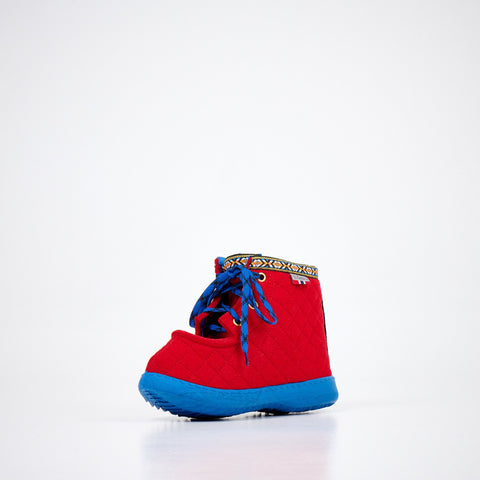4. Studio image of Nesna Lobben red felt boot with blue sole, featuring decorative trim and blue laces