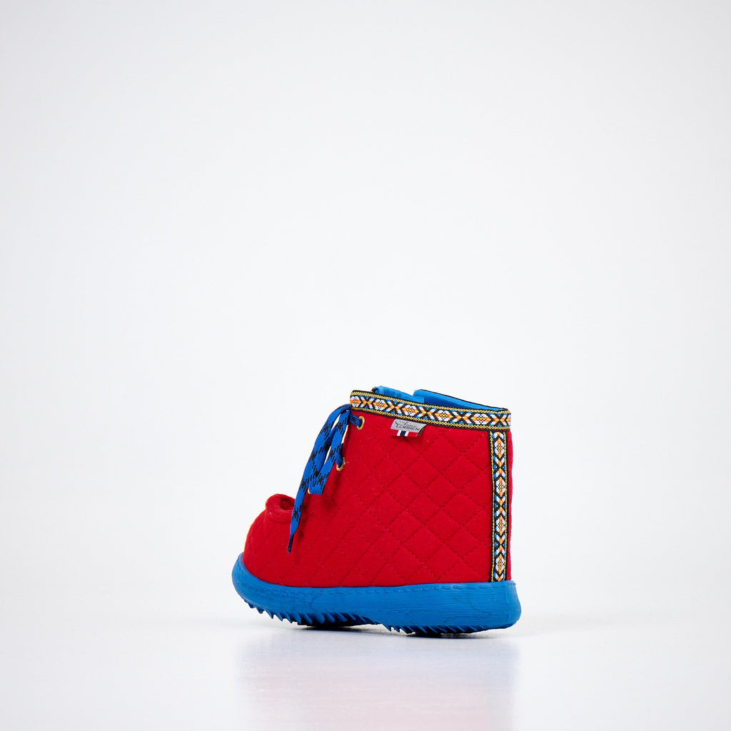 3. Back view of Nesna Lobben red felt boots with blue soles, highlighting decorative trim and quilted texture