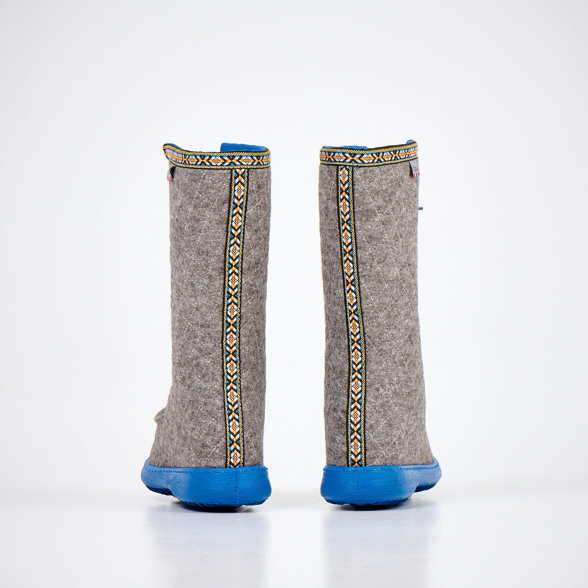 2. Back view of Nesna Lobben Polar Lobben Felt Boots in grey with decorative trim and blue soles, studio shot