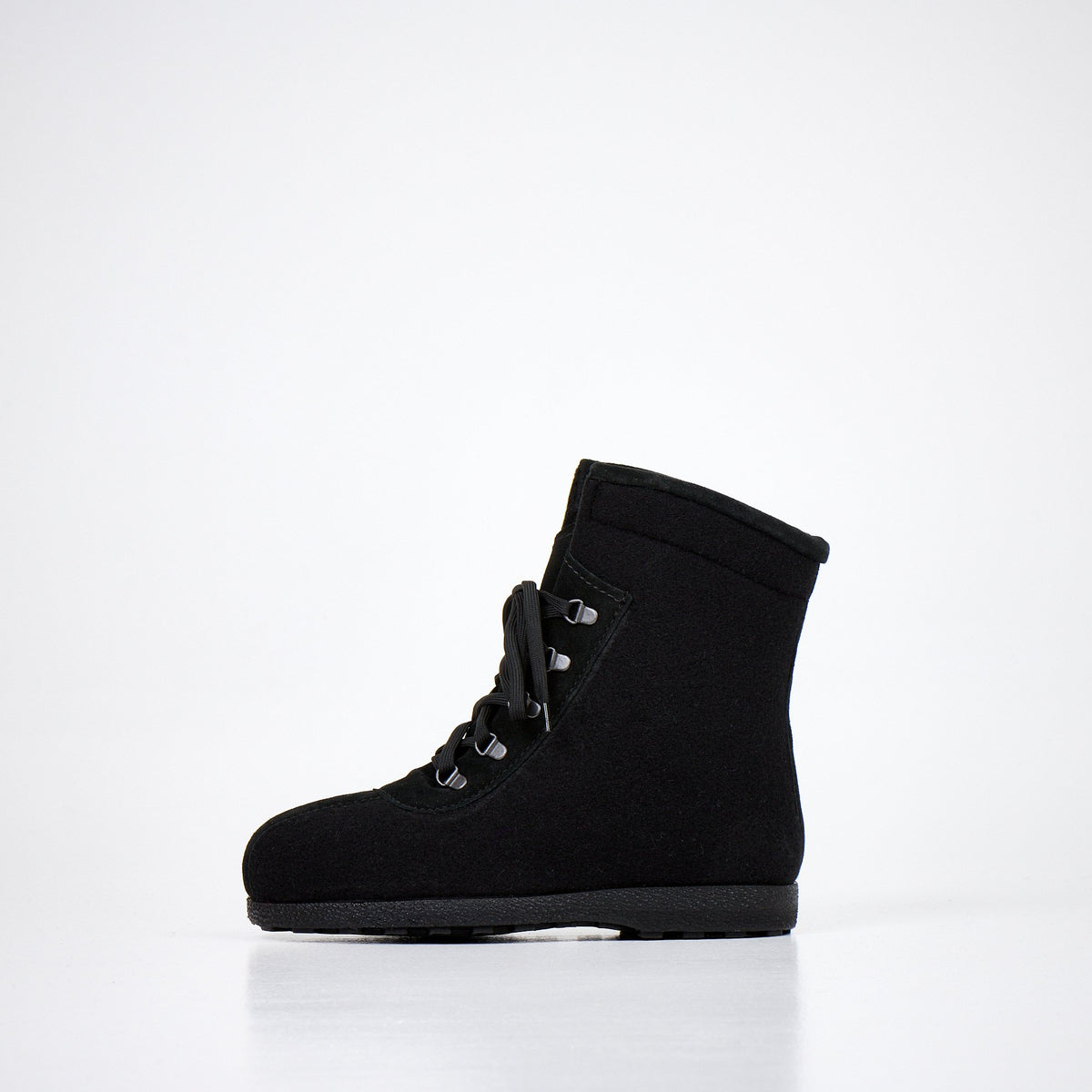 1. Studio shot of Nesna Lobben black felt boots, side view showing lace-up design and polyurethane moulded soles