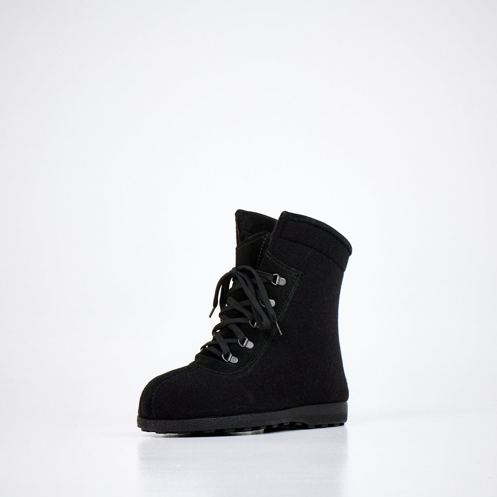 3. Studio image of Nesna Lobben black felt boots, angled view showcasing lace-up front and deep groove soles