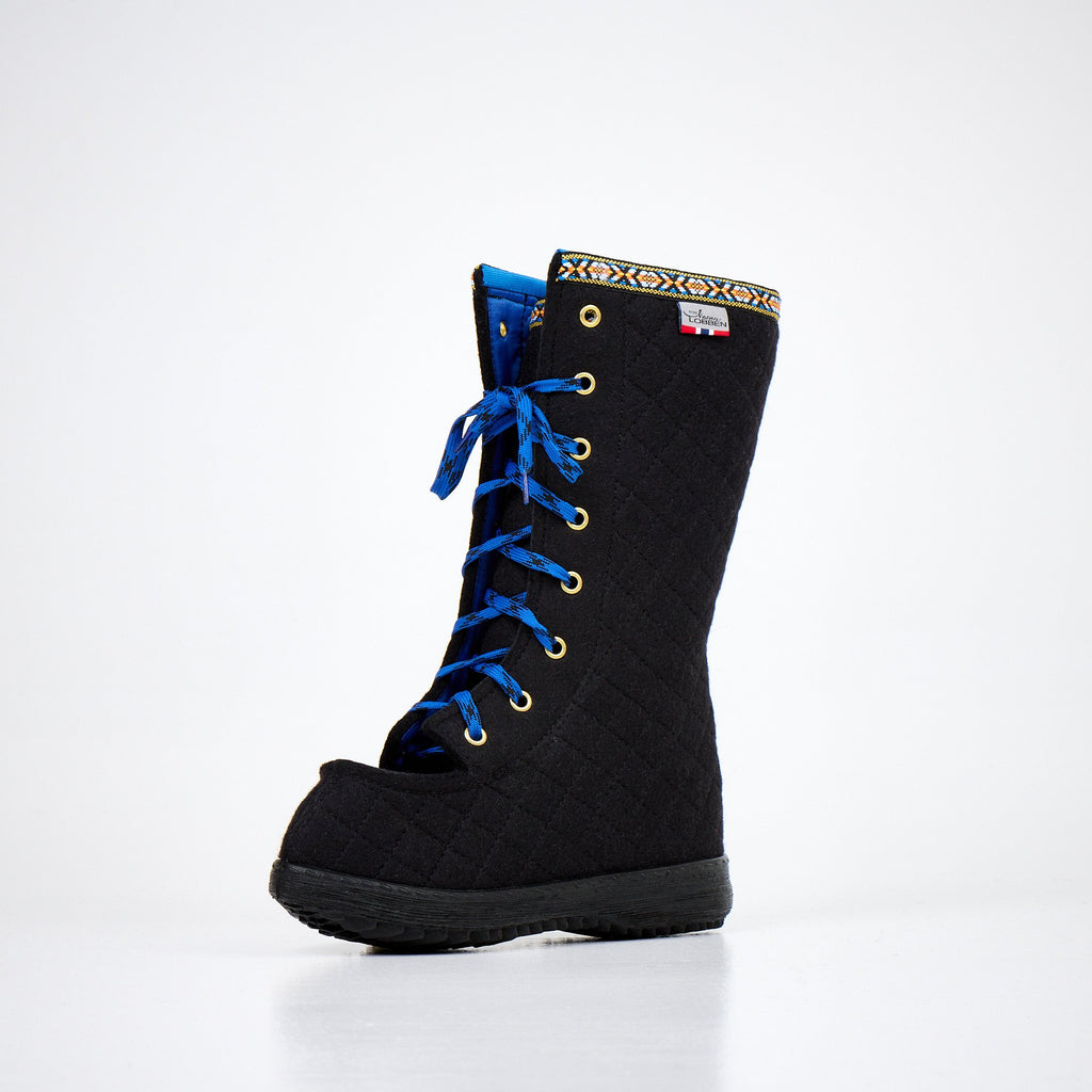 3. Angled side view of Nesna Lobben Polar Lobben Felt Boots in black with blue laces, studio setting