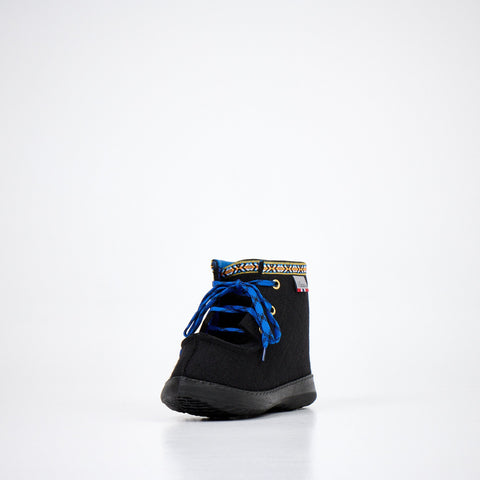 1. Studio side view of Nesna Lobben black felt boots with blue laces and patterned trim, showcasing polyurethane sole