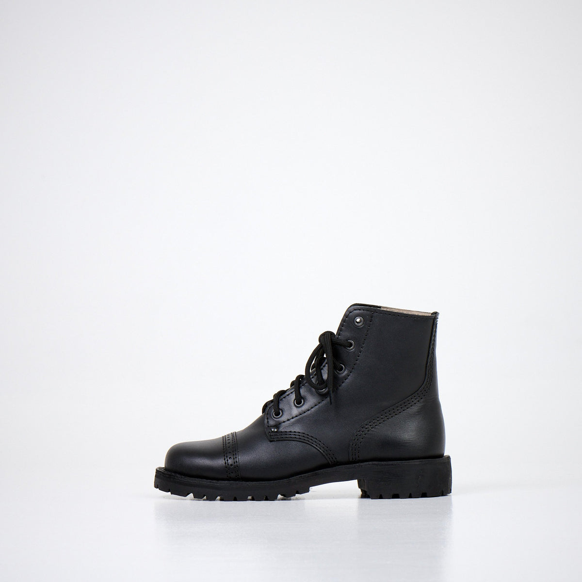 3. Side profile of AIPI A-PS-2 black boots, featuring natural leather upper and EVA insole, shown in studio