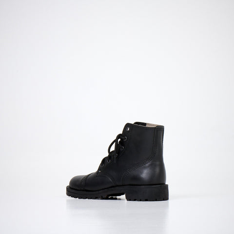 2. Side view of AIPI A-PS-2 black leather boots with lace-up design, highlighting rugged style and robust sole in studio