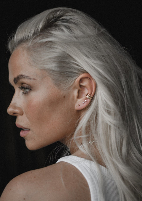 3. Woman with blonde hair wearing NO MORE Pin Up Earrings in sterling silver, styled with additional ear jewelry