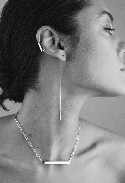 1. Woman wearing NO MORE Pin Up Threader Chain Earrings in silver, styled with a matching necklace, showcasing minimalist elegance