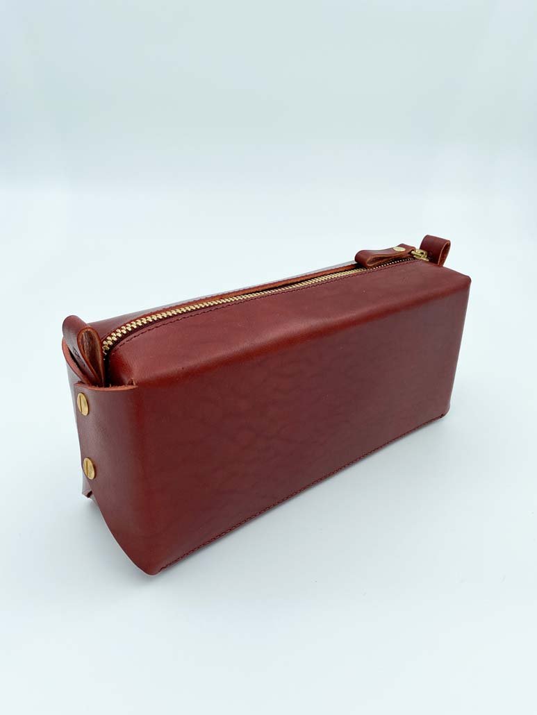 2. Brown leather makeup bag by Stella Soomlais with gold zipper on white background, highlighting sleek design