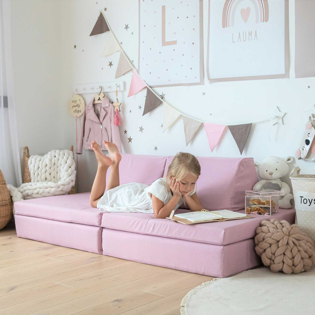 1. Girl reading on pink play mattress set in a decorated room